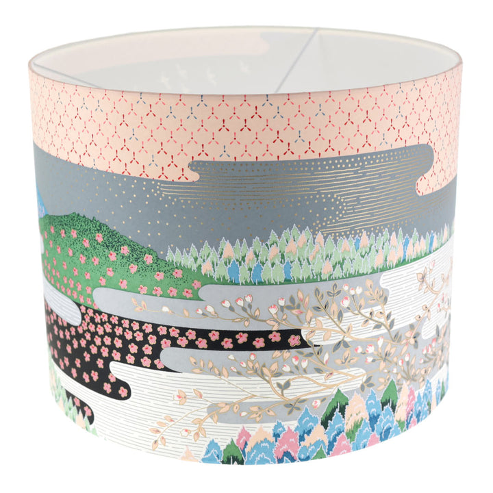 photo packshot avec une vue de face d'un abat-jour japonais au motif de paysage japonais (ciel et montagne) dans les tons bleus, verts, gris, noirs, orange et roses