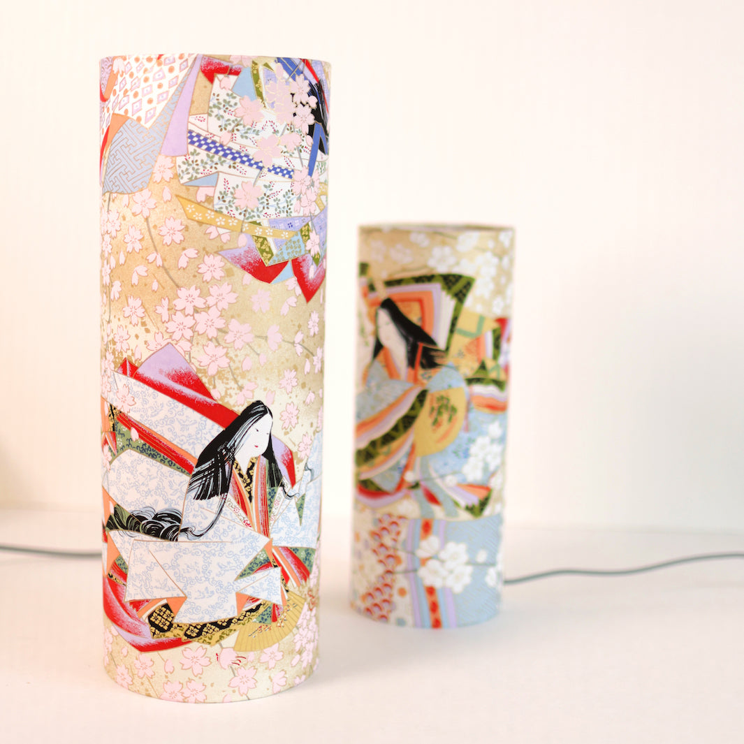 photo packshot avec une vue de face en biais de lampes à poser japonaise (taille s et m) au motif de femmes en kimono dans les tons mordorés, rouges, verts, bleus et mauves