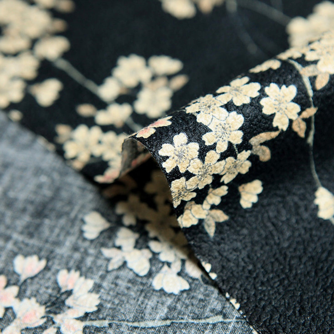 photo packshot zoomée d'un détail du tissu japonais aux motifs de fines branches de fleurs de cerisier dans les tons noirs, crème et rose clair T333