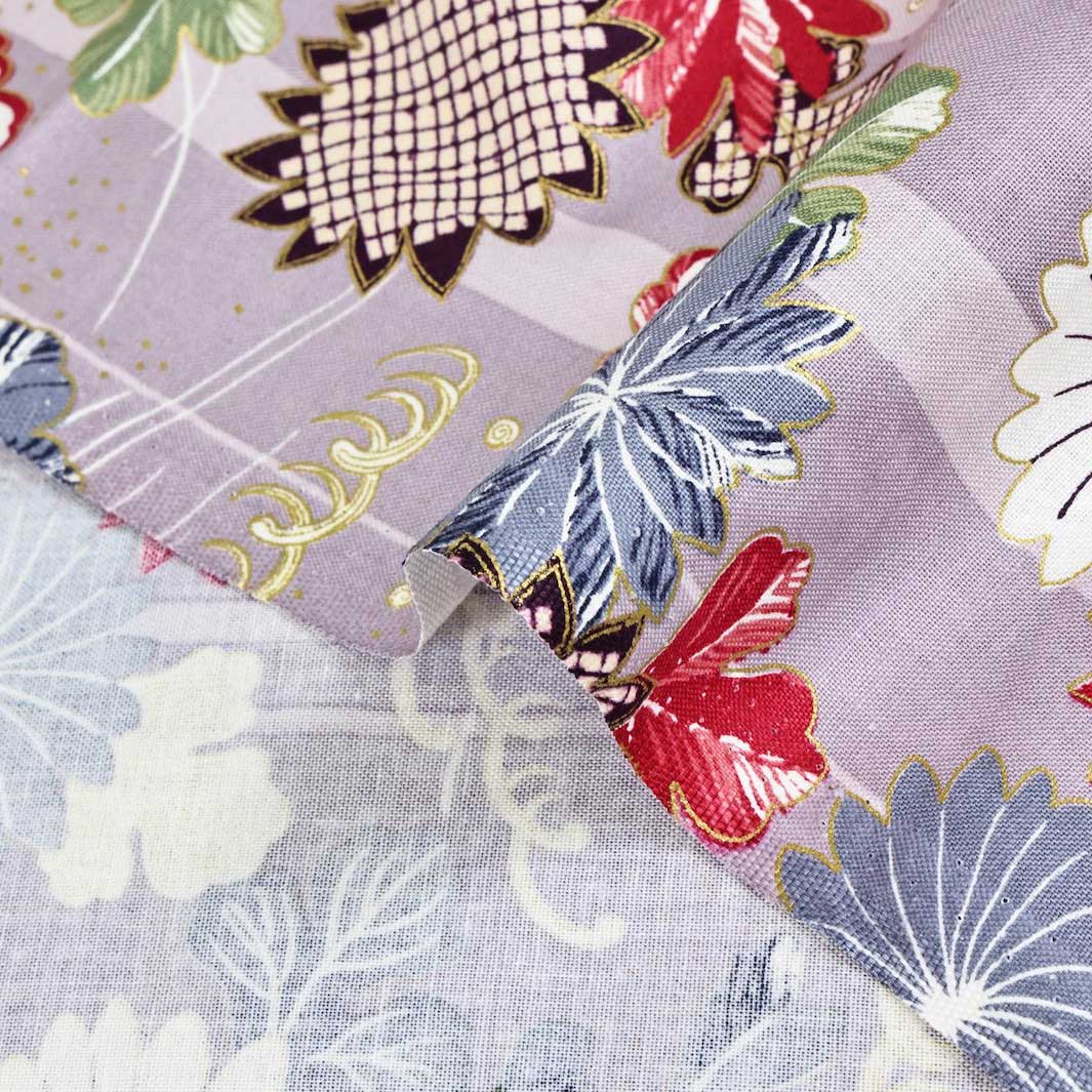 photo packshot zoomée d'un détail du tissu japonais aux motifs de chrysanthèmes et de mouvements de brise dans les tons mauve clair, bleu gris, rouge, vert foncé et dorés T547