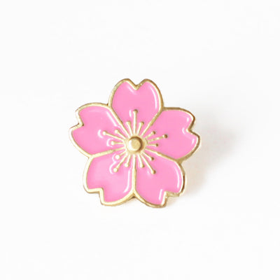photo packshot d'un pin's en forme de fleur de cerisier rose moyen aux détails dorés