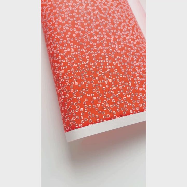 vidéo de démonstration du papier japonais yuzen chiyogami aux motifs de semi de fleurs blanches sur fond orange rouge adeline klam (M1069)