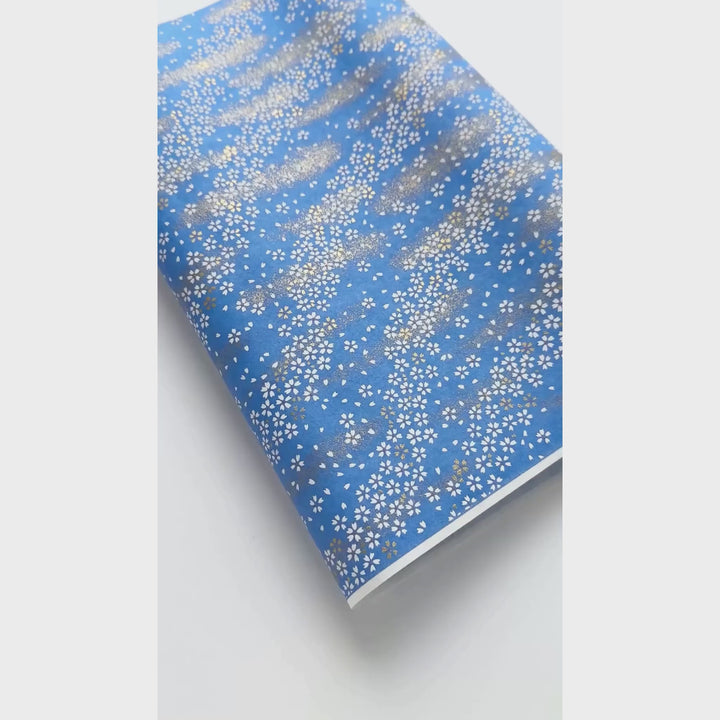 vidéo de démonstration du papier japonais yuzen chiyogami au motif de petits fleurs blanches au vent sur fond bleu pervenche adeline klam (M983)