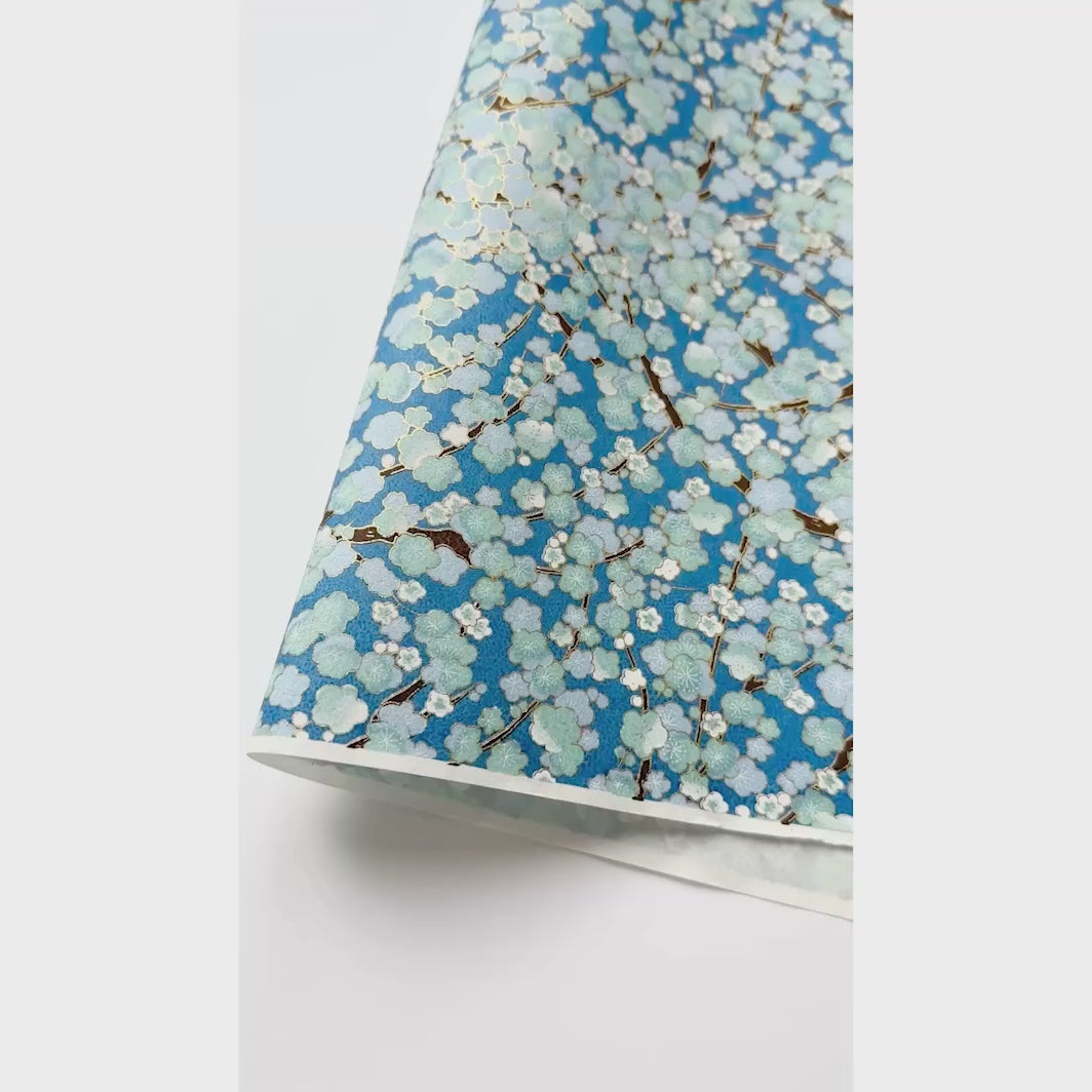 vidéo de démonstration du papier japonais yuzen chiyogami aux motifs de de fleurs de prunier dans les tons bleu foncé, bleu ciel et vert d'eau adeline klam (M448)