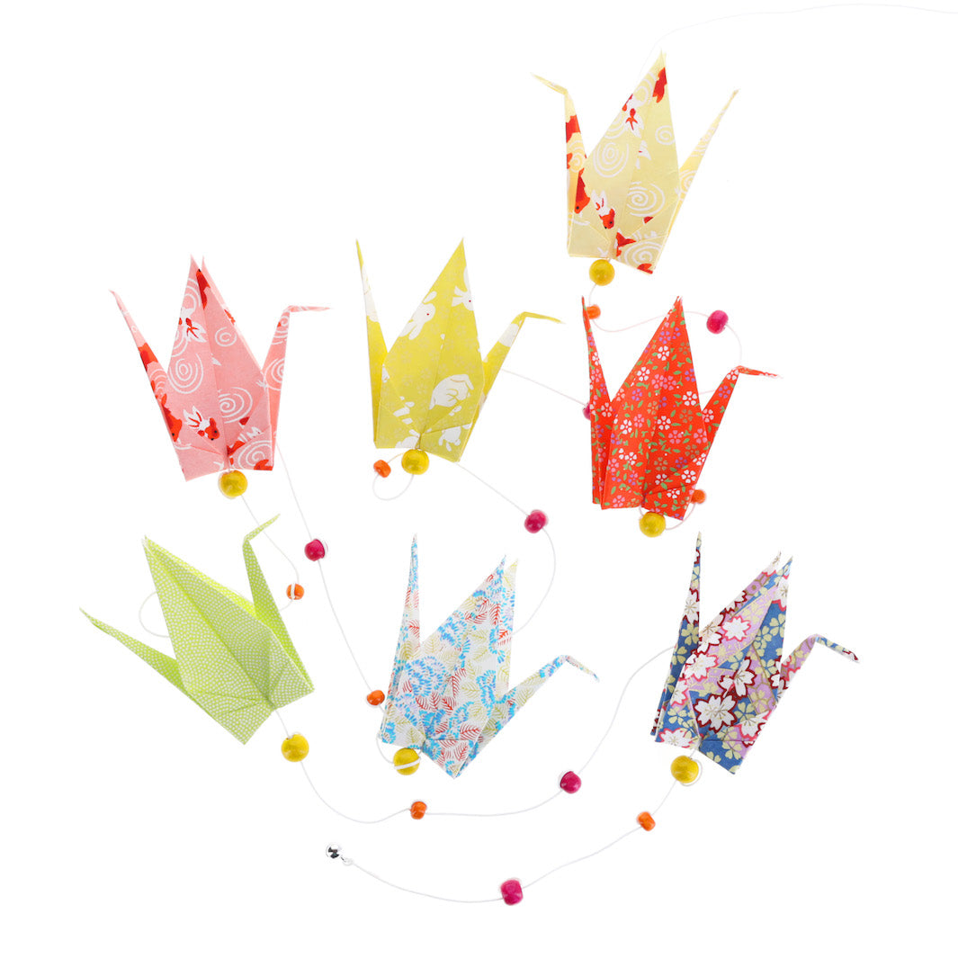 vue du dessus de la guirlande montée du kit créatif guirlande de grues en origami « granité » (K9) dans les tons jaunes, rouge orangé, roses, vert acidulé, bleus et mauve