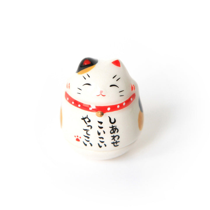 culbuto japonais en forme de maneki-neko au pelage tacheté noir, blanc et jaune