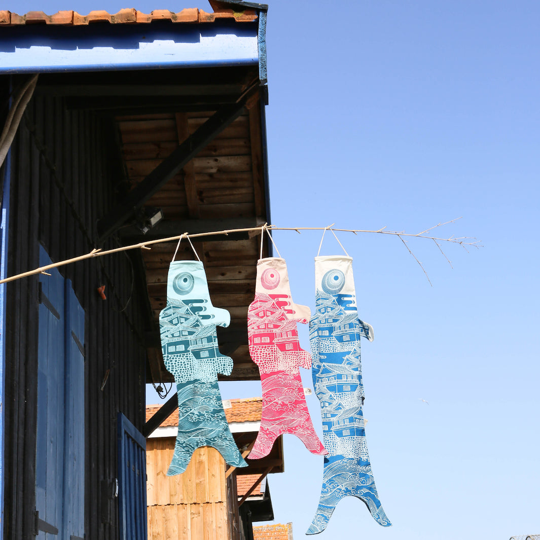 photo d'ambiance de koinobori madame mo suspendus de la collection « ôshiro » de couleurs blanches, bleues et roses