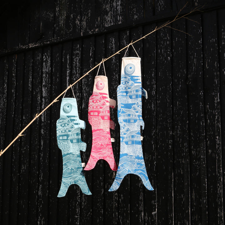 photo d'ambiance de koinobori madame mo suspendus de la collection « ôshiro » de couleurs blanches, bleues et roses